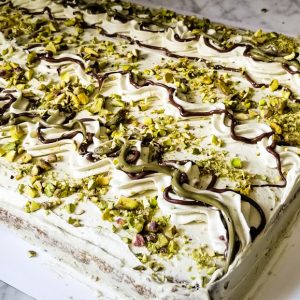 16 × 12-inch Italian pistachio cake with creamy buttercream, pistachio cream, chocolate, and crushed pistachios on a cake board.